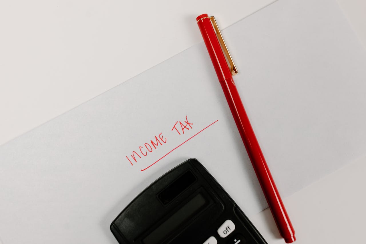 The Art of Drawing Readers In: Your attractive post title goes here Close-up of a calculator and red pen on paper labeled 'Income Tax', representing financial planning.